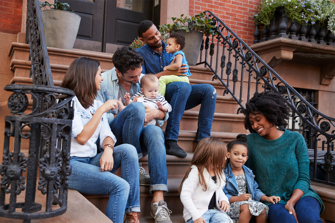 Multi-Ethnic Families and Friends on Front Steps of Residential Building